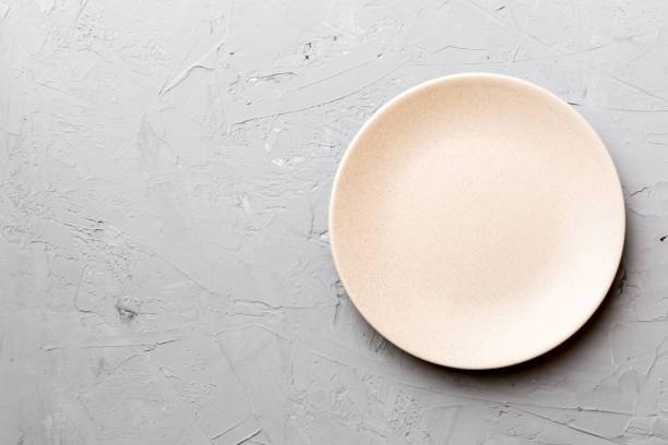 istock Top view of empty pink plate on cement background. Empty space for your design 1408528490