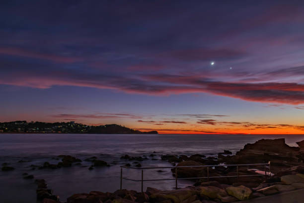 First light over the ocean with 9 percent sliver of moon and stars Dawn seascape with high cloud at Avoca Beach on the Central Coast, NSW, Australia. avoca beach photos stock pictures, royalty-free photos & images