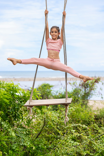 Girl doing acrobatics on a swing