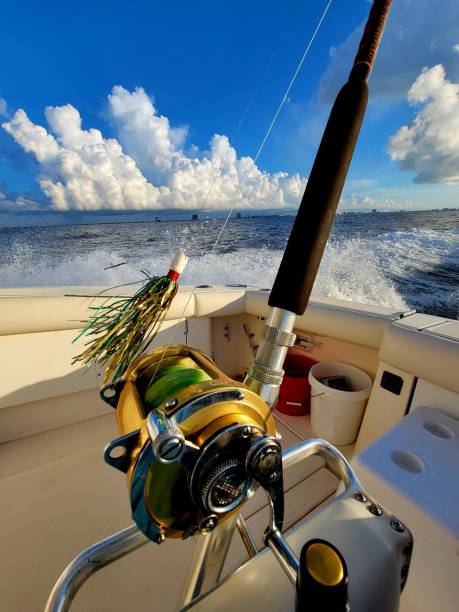 Saltwater fishing reel and lure Saltwater fishing rod reel lure Gulf of Mexico blue sky white clouds big game fishing stock pictures, royalty-free photos & images