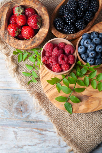 istock Colorful berries assortment on rustic wooden table 1408531832