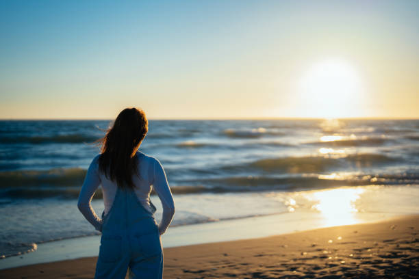 istock unrecognizable red-haired woman on the beach watching the sunset 1408537310