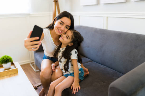 Gorgeous mom and daughter feeling happy while taking a selfie