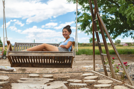 Agricultural Lifestyle in Arid Desert Climate Showing Teenage Rural Life in Western USA Kazan Asian Teen Female Living on a Farm Swinging on a Wooden Porch Swing Photo Series - 4K Matching Video Available