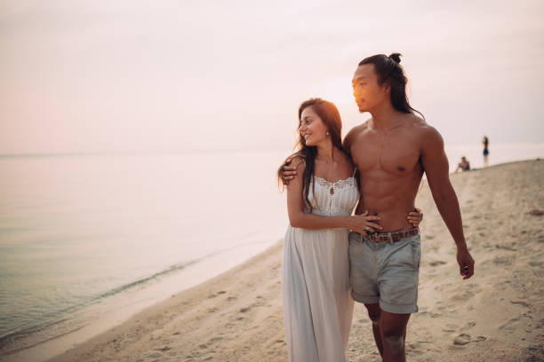 couple enjoying the beach walk - couple human pregnancy sunset walking imagens e fotografias de stock