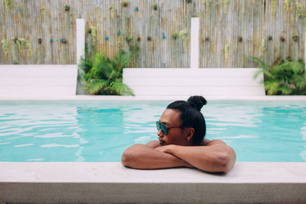 istock Asian man enjoying poolside on his vacation 1408557148