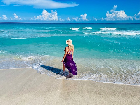 Young white woman walking on the beach  over coastline, Cancun, Mexico