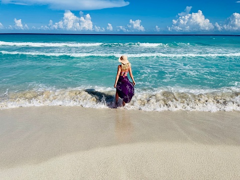 Young white woman walking on the beach  over coastline, Cancun, Mexico