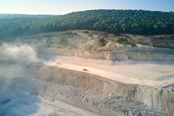 istock Aerial view of open pit mining of limestone materials for construction industry with excavators and dump trucks. 1408564667