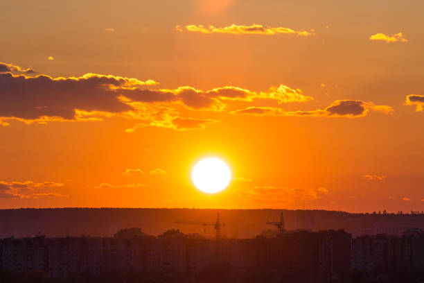 Bright colorful sunset sky with rays of setting sun and vivid dark clouds.
