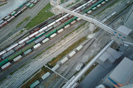 Aerial view of cargo train cars loaded with construction goods at mining factory. Railway transportation of industrial production raw materials.