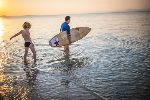 Photo father and son going to surf together