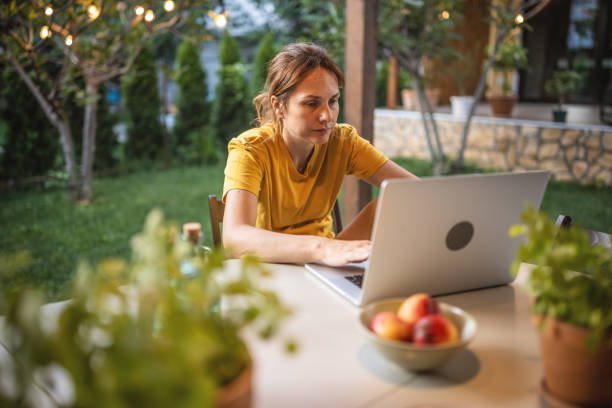 istock Woman with laptop working in garden 1408567764