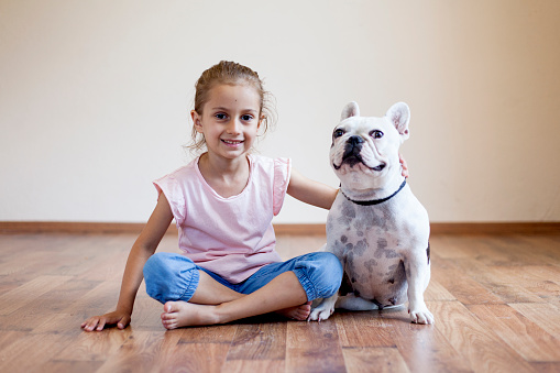 little girl having fun with her dog indoors