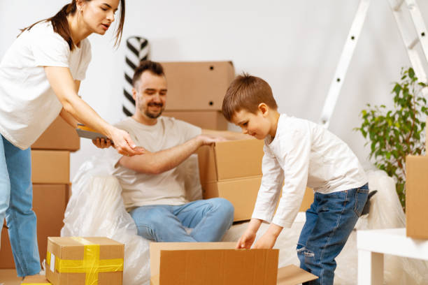 istock Parents and son packing boxes and moving into a new home 1408575092