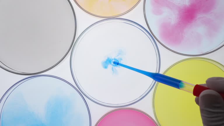 Blue liquid dropping into petri dish