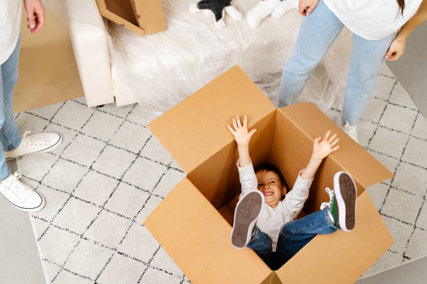 istock Little boy playing inside a moving box on a moving day 1408576762
