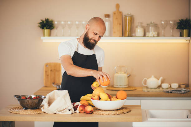 istock Millennial man preparing ingridients for making smoothies at the kitchen. 1408580238