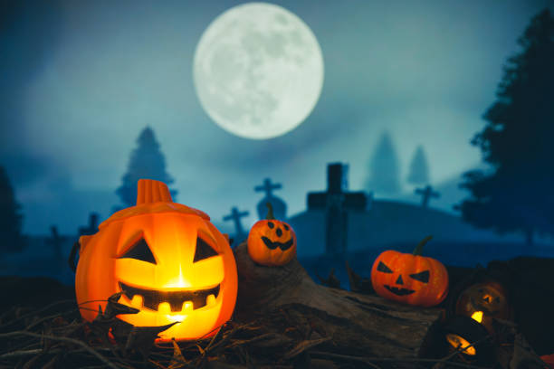 istock Spooky cemetery with glow halloween pumpkin 1408580619