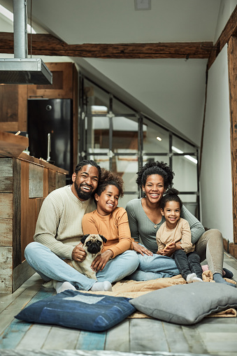 Happy African American family and their dog enjoying at home.