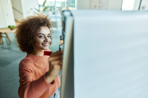 istock Happy female leader writing plans on a seminar. 1408582918