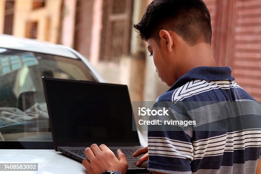 istock Teenage boy using laptop 1408583002