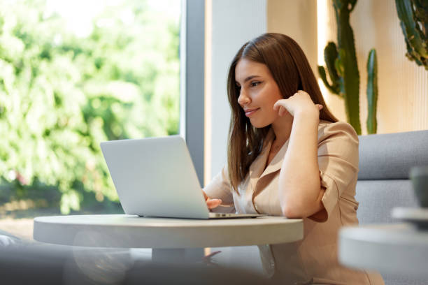 istock Young businesswoman using a laptop during a coffee break in coffeeshop 1408583394
