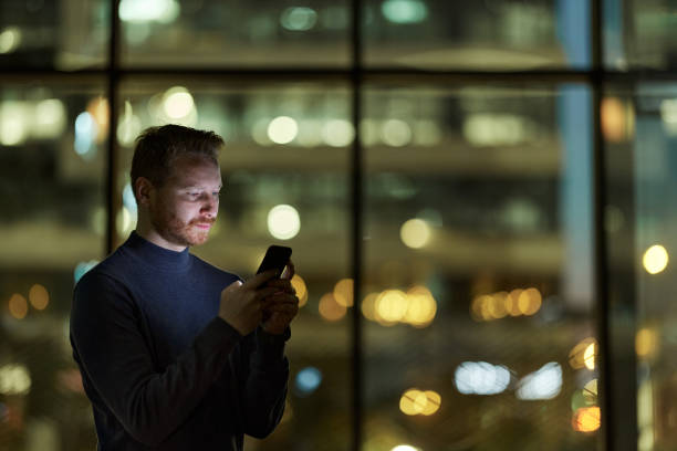istock Redhead man text messaging on cell phone indoors at night. 1408584048