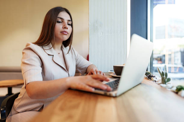 istock Young businesswoman using a laptop during a coffee break in coffeeshop 1408584991