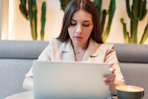 istock Young businesswoman using a laptop during a coffee break in coffeeshop 1408586134