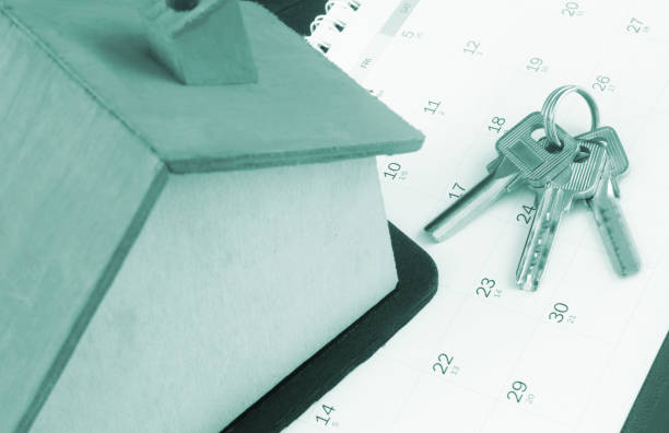 istock Wooden house model on calendar page with keys. 1408587912