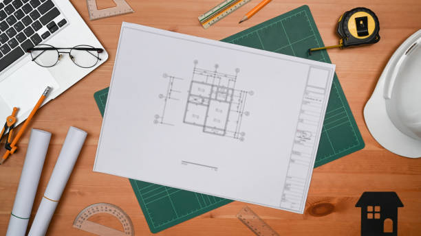 istock Flat lay blueprints, laptop, helmet, house model and tools on wooden table. Engineer, Architect workspace. 1408588594