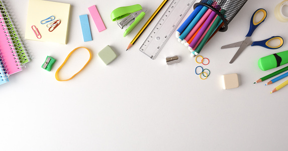 Background with school supplies on white table on top. Top view. Horizontal panoramic composition.