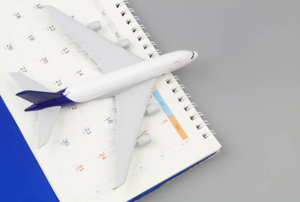 istock Airplane and calendar on grey background close-up. 1408589770