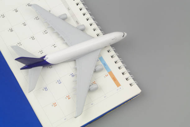 istock Airplane and calendar on grey background close-up. 1408589780