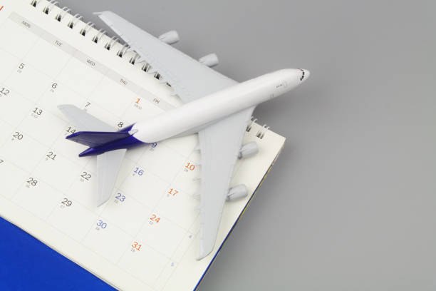 istock Airplane and calendar on grey background close-up. 1408589888
