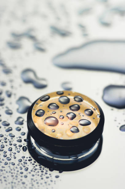 Abstract golden shiny object with droplets. Round wet object close up view.