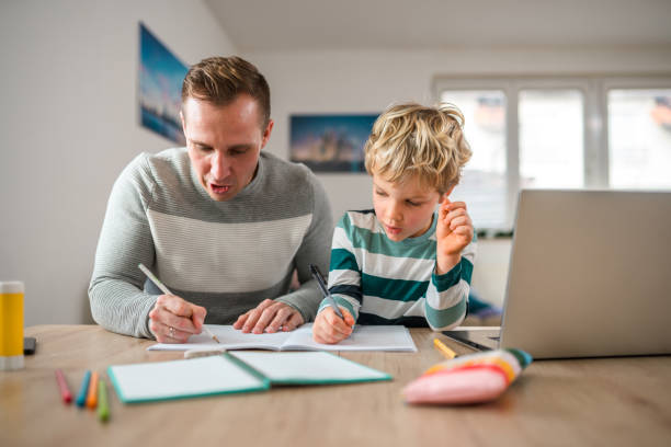 istock Caucasian Father and Son at Desk, Writing and Learning Together 1408591109