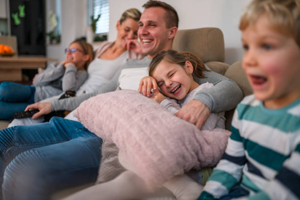 istock White Family Having a Good Laugh while Seated at Sofa 1408591181