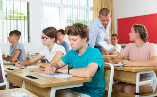 istock Teenage students making notes of teacher lecture in class 1408593959
