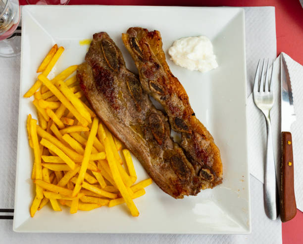 istock Spanish cuisine churrasco de ternera, spare ribs with potatoes on white ceramic plate 1408595987