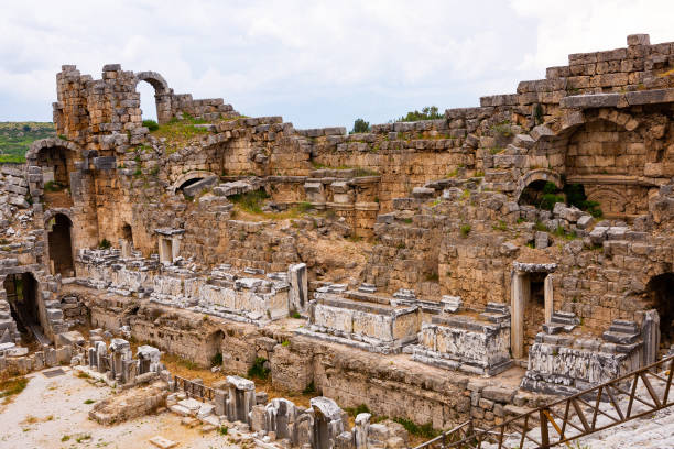 ruines de l’ancien amphithéâtre (théâtre) à perge. construite dans le style gréco-romain, perge est une ancienne ville grecque d’antalya - greco roman photos photos et images de collection