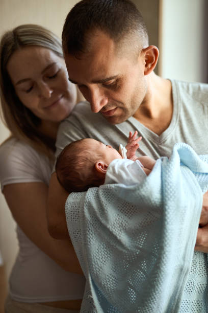 istock Woman and man holding a newborn. 1408598945