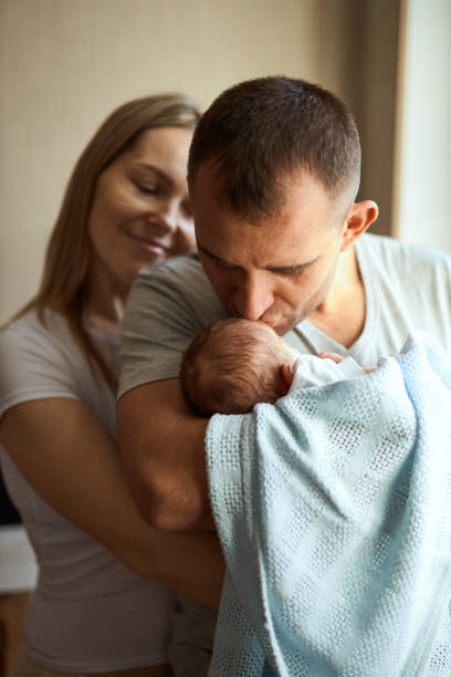 istock Woman and man holding a newborn. 1408598951