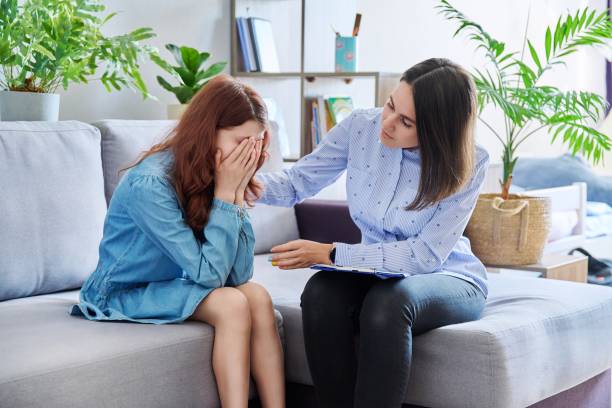 Female professional child psychologist working with preteen girl in office stock photo
