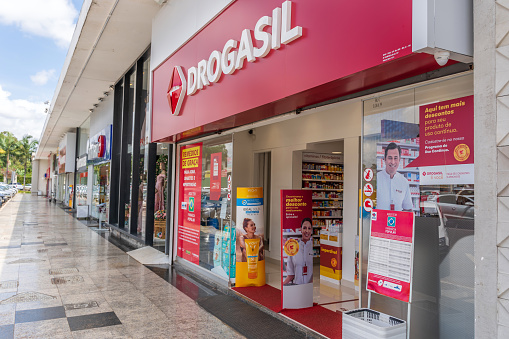 Brasilia commercial block which accompany all residential blocks in the city. The main focus is store front of Drogasil Pharmacy. No people are visible in the image.