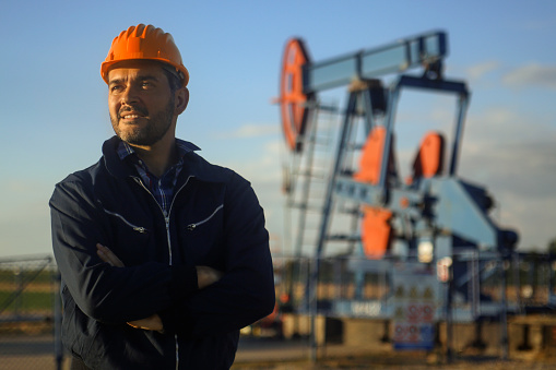 Oil industry worker working in an oil field. About 45 years old, Caucasian male.