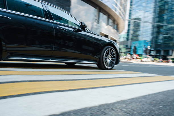 istock Black luxury car riding at the financial downtown district, blurred in motion. 1408605944