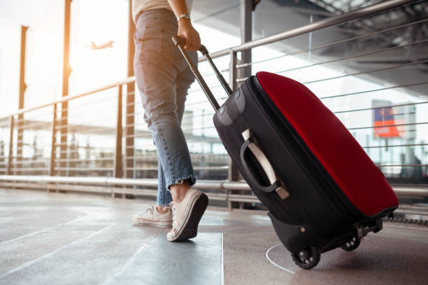 viajante com mala no conceito de aeroporto. jovem menina andando com transporte de bagagem e passageiros para o voo de bilhete tour viagens reserva em tempo de férias internacionais em férias de descanso e relaxamento. - travel insurance - fotografias e filmes do acervo