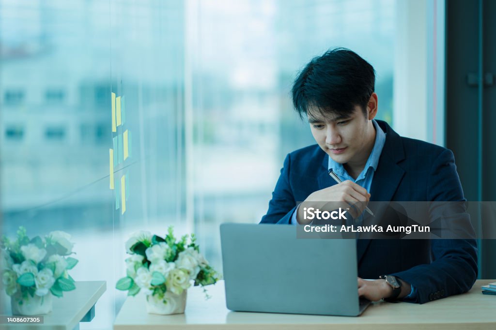 Young Asian businessman video conferencing in a virtual workplace or remote office. Conferencing using intelligent video technology to communicate with colleagues in enterprise businesses. Seminar Stock Photo